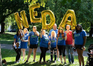 Our Work people holding NEDA balloons